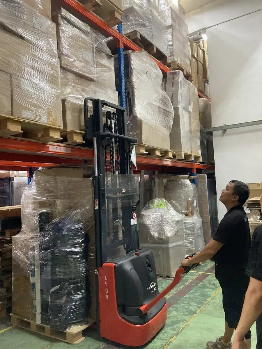A Reddot staff member using a stacker in the warehouse
